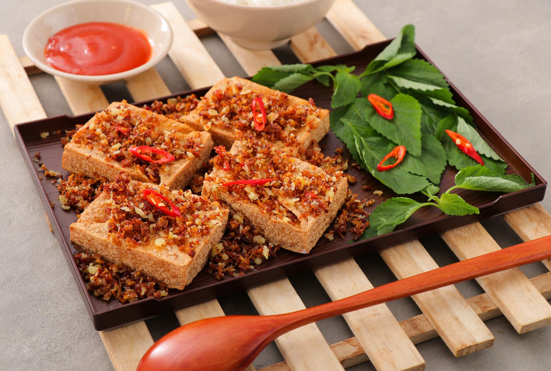 Hình ảnh sợi mì đang được đảo đều trong chảo cùng với nước sốt sền sệt và rau củ